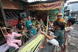 Sejumlah warga mengikuti pembelajaran cara membuat kulit ketupat di Jalan Kenjeran, Surabaya, Jawa Timur, Sabtu (5/4/2025). Pembelajaran membuat kulit ketupat oleh komunitas Kampoeng Dolanan kepada warga di tempat itu bertujuan agar peserta mampu menganyam sendiri janur menjadi kulit ketupat sehingga tradisi membuat ketupat untuk Lebaran Ketupat tetap lestari. Antara Jatim/Didik Suhartono/um