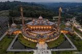 Foto udara sejumlah pemudik berkunjung di masjid bergaya arsitektur timur tengah di Masjid An-Nahdla, Margomulyo, Bojonegoro, Jawa Timur, Minggu (6/4/2025). Masjid yang dibangun pemerintah setempat dengan anggaran senilai Rp113,45 miliar yang berada di ruas jalan nasional Ngawi - Bojonegoro itu dikunjungi ribuan pemudik sebagai tempat persinggahan favorit untuk beristirahat sekaligus berwisata saat arus mudik maupun arus balik lebaran. Antara Jatim/Muhammad Mada/um