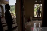 Warga memeriksa kondisi rumah yang rusak akibat pergerakan tanah di Kampung Babut Tengah, Cibabat, Kota Cimahi, Jawa Barat, Selasa (8/4/2025). Berdasarkan data BPBD Kota Cimahi, sebanyak 10 rumah rusak dan 35 jiwa terdampak akibat bencana pergerakan tanah yang melanda kampung tersebut pada Senin (7/4). ANTARA FOTO/Abdan Syakura/agr