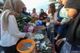 Warga antre untuk mendapatkan hidangan gratis saat Lebaran Ketupat di Sukolilo Baru, Surabaya, Jawa Timur, Senin (7/4/2025). Tradisi yang dirayakan sepekan setelah Hari Raya Idul Fitri di kawasan pemukiman di Pantai Kenjeran itu digelar dengan membagikan berbagai hidangan secara gratis kepada warga sekitar dan sebagai ajang untuk bersilaturahim. ANTARA Jatim/Didik Suhartono/mas.