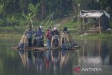 Warga berada di atas rakit eretan saat menyeberangi sungai Citarum di Batujajar, Kabupaten Bandung Barat, Jawa Barat, Rabu (9/4/2025). Jasa penyeberangan rakit eretan dengan tarif Rp1.000 - Rp5.000 tersebut mayoritas digunakan para buruh pabrik dan warga sekitar sebagai alternatif transportasi untuk mempersingkat waktu serta jarak tempuh. ANTARA FOTO/Abdan Syakura/agr