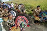 Sejumlah seniman memainkan tarian kuda lumping mengiringi ritual labuh masal kaki sedono (padi jantan) dan nini sedono (padi betina) di Tulungagung, Jawa Timur, Jumat (11/4/2025). Upacara labuhan itu digelar setiap jelang panen raya padi dan telah menjadi tradisi turun-temurun sebagai wujud rasa syukur sekaligus doa agar hasil pertanian terus melimpah di daerah itu. Antara Jatim/Destyan Sujarwoko/um
