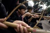 Pelajar mencoba permainan tradisional pada program Abdi Nagri Nganjang Ka Warga di halaman Bale Pakuan/ Gedung Pakuan, Bandung, Jawa Barat, Sabtu (12/4/2025). Sejumlah permainan tradisional Jawa Barat seperti Egrang, Rorodaan, Pistol Bambu hingga engklek dikenalkan saat kegiatan tersebut sebagai edukasi dan peningkatan motorik anak sekaligus menumbuhkan nilai kepedulian budaya dalam melestarikan permainan tradisional Jawa Barat. ANTARA FOTO/Novrian Arbi/agr