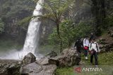 Wisatawan berjalan di dekat Curug Bugbrug di Cisarua, Kabupaten Bandung Barat, Jawa Barat, Minggu (13/4/2025). Air terjun atau curug yang dikelola oleh Perhutani KPH Bandung Utara dengan Lembaga Masyarakat Desa Hutan (LMDH) Cihanjuang Rahayu tersebut memiliki ketinggian sekitar 25 meter dan menjadi potensi wisata unggulan yang dapat meningkatkan kunjungan pariwisata serta perekonomian masyarakat di kawasan tersebut. ANTARA FOTO/Abdan Syakura/agr
