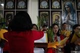 Umat Katolik bernyanyi saat Misa Minggu Palma di Gereja Katolik Kelahiran Santa Perawan Maria di Jalan Kepanjen, Surabaya, Jawa Timur, Minggu (13/4/2025). Misa Minggu Palma itu merupakan rangkaian perayaan Paskah serta guna memperingati datangnya Yesus di Yerusalem. ANTARA Jatim/Didik Suhartono/mas.