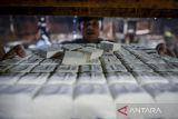 Pekerja menata tahu mentah yang telah selesai diproduksi di Cipondoh, Kota Tangerang, Banten, Senin (14/4/2025). Produsen tahu setempat mengeluhkan harga kedelai impor yang sudah naik tiga kali sejak sepekan terakhir dari Rp9.900 menjadi Rp10.600 per kilogram yang berdampak terhadap meningkatnya biaya produksi tahu dan omzet mereka. ANTARA FOTO/Putra M. Akbar/gp