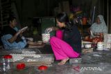 Perajin mengangkut kue kering yang telah dijemur di rumah industri Ibnu Jaya Abadi, Kasemen, Kota Serang, Banten, Rabu (16/4/2025). Kementerian Usaha Mikro, Kecil, Menengah (UMKM) mencatat pencapaian realisasi Kredit Usaha Rakyat (KUR) pada triwulan pertama tahun 2025 telah mencapai Rp57,51 triliun yang disalurkan kepada kurang lebih 1,014 juta debitur di seluruh Indonesia. ANTARA FOTO/Angga Budhiyanto/gp