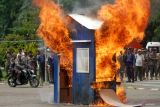 Petugas dari Satuan Polisi Pamong Praja dan Perlindungan Masyarakat melihat api yang membakar rumah saat simulasi penyelamatan dalam kebakaran di Alun Alun Sidoarjo, Jawa Timur, Kamis (17/4/2025). Simulasi yang diikuti Satuan Polisi Pamong Praja, Satuan Perlindungan Masyarakat dan Pemadam Kebakaran tersebut bertujuan untuk meningkatkan kemampuan dan kesiapsiagaan menghadapi bencana di Indonesia serta penyelamatan korban. Antara Jatim/Umarul Faruq