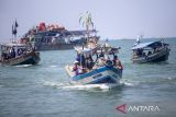 Warga berada di dalam perahu saat mengikuti prosesi larung sesaji tradisi pesta laut atau nadran nelayan di Karangsong, Indramayu, Jawa Barat, Rabu (16/4/2025). Tradisi nadran atau pesta laut nelayan Karangsong itu biasa digelar dua tahun sekali sebagai bentuk syukur nelayan atas hasil tangkapan ikan. ANTARA FOTO/Dedhez Anggara/agr
