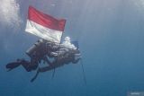 Pembawa Bendera Merah Putih Lettu Laut (PM) R. Farras Kurniawan (kiri) bersama Pembawa Bendera Amerika Captain USMC Josh Cambers (kanan) melakukan penyelaman untuk memasang Prasasti dan Pengibaran Bendera Indonesia dan Amerika di area Kapal karam Amerika USAT Liberty di Perairan Tulamben, Desa Tulamben, Kubu, Bali, Kamis (17/4/2025). Penyelaman dan pemasangan prasasti yang dilaksanakan oleh Naval Historical Diver Dinas Sejarah AL dan Kedutaan Besar Amerika untuk Indonesia tersebut digelar sebagai penghormatan terhadap situs sejarah USAT Liberty, pengingat akan kerja sama antar bangsa, serta pelestarian warisan budaya bawah laut di Indonesia. ANTARA FOTO/Muhammad Adimaja/wsj.