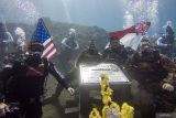 Perwira Pelaksana Penyelaman Naval Historical Diver Disjarahal Letkol Laut (P) Yudo Ponco (kedua kanan) melakukan salam komando dengan Perwakilan Marinir Amerika Captain USMC Josh Cambers (kedua kiri) usai pemasangan Prasasti dan Pengibaran Bendera Indonesia dan Amerika di area Kapal karam Amerika USAT Liberty di Perairan Tulamben, Desa Tulamben, Kubu, Bali, Kamis (17/4/2025). Penyelaman dan pemasangan prasasti yang dilaksanakan oleh Naval Historical Diver Dinas Sejarah AL dan Kedutaan Besar Amerika untuk Indonesia tersebut digelar sebagai penghormatan terhadap situs sejarah USAT Liberty, pengingat akan kerja sama antar bangsa, serta pelestarian warisan budaya bawah laut di Indonesia. ANTARA FOTO/Muhammad Adimaja/wsj.