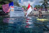 Pembawa Bendera Merah Putih Lettu Laut (PM) R. Farras Kurniawan bersiap melakukan penyelaman untuk memasang Prasasti dan Pengibaran Bendera Indonesia dan Amerika di area Kapal karam Amerika USAT Liberty di Perairan Tulamben, Desa Tulamben, Kubu, Bali, Kamis (17/4/2025). Penyelaman dan pemasangan prasasti yang dilaksanakan oleh Naval Historical Diver Dinas Sejarah AL dan Kedutaan Besar Amerika untuk Indonesia tersebut digelar sebagai penghormatan terhadap situs sejarah USAT Liberty, pengingat akan kerja sama antar bangsa, serta pelestarian warisan budaya bawah laut di Indonesia. ANTARA FOTO/Muhammad Adimaja/wsj.