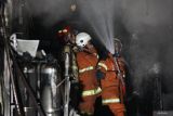 Petugas Dinas Pemadam Kebakaran dan Penyelamatan Kota Surabaya melakukan proses pembasahan rumah toko yang terbakar di Jalan Kedung Rukem IV, Surabaya, Jawa Timur, Kamis (17/4/2025). Sebanyak 15 kendaraan pemadam kebakaran dikerahkan untuk memadamkan kebakaran rumah yang sekaligus berfungsi sebagai toko di kawasan pemukiman padat penduduk dan mengakibatkan dua orang penghuninya meninggal dunia di lokasi itu. ANTARA Jatim/Didik Suhartono/mas.