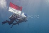 Pembawa Bendera Merah Putih Lettu Laut (PM) R. Farras Kurniawan (kiri) bersama Pembawa Bendera Amerika Captain USMC Josh Cambers (kanan) melakukan penyelaman untuk memasang Prasasti dan Pengibaran Bendera Indonesia dan Amerika di area Kapal karam Amerika USAT Liberty di Perairan Tulamben, Desa Tulamben, Kubu, Bali, Kamis (17/4/2025). Penyelaman dan pemasangan prasasti yang dilaksanakan oleh Naval Historical Diver Dinas Sejarah AL dan Kedutaan Besar Amerika untuk Indonesia tersebut digelar sebagai penghormatan terhadap situs sejarah USAT Liberty, pengingat akan kerja sama antar bangsa, serta pelestarian warisan budaya bawah laut di Indonesia. ANTARA FOTO/Muhammad Adimaja/foc.
