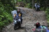 Petugas PPS membawa logistik PSU Pilkada Kabupaten Serang 2024 menerobos jalan rusak di Desa Cikedung, Kabupaten Serang, Banten, Jumat (18/4/2025). KPU Kabupaten Serang mendistribusikan logistik pemungutan suara ulang (PSU) Pilkada Kabupaten Serang 2024 ke wilayah desa terpencil di Desa Cikedung dengan kondisi topografi pegunungan dan hanya dapat diakses menggunakan sepeda motor yang memakan waktu tempuh hingga satu jam dari kantor Kecamatan Mancak. ANTARA FOTO/Muhammad Bagus Khoirunas/gp