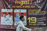 Pengendara roda dua melintas di depan spanduk sosialisasi PSU Pilkada Kabupaten Serang 2024 di Kecamatan Mancak, Kabupaten Serang, Banten, Jumat (18/4/2025). KPU Kabupaten Serang menargetkan partisipasi pemilih untuk pemungutan suara ulang (PSU) Pilkada Kabupaten Serang 2024 mencapai sebesar 73,6 persen dari total daftar pemilih tetap (DPT) yaitu sebanyak 1.225.871 yang terdiri dari 621.527 pemilih laki-laki dan 604.344 pemilih perempuan. ANTARA FOTO/Muhammad Bagus Khoirunas/gp