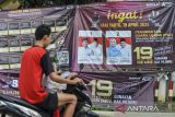 Pengendara roda dua melintas di depan spanduk sosialisasi PSU Pilkada Kabupaten Serang 2024 di Kecamatan Mancak, Kabupaten Serang, Banten, Jumat (18/4/2025). KPU Kabupaten Serang menargetkan partisipasi pemilih untuk pemungutan suara ulang (PSU) Pilkada Kabupaten Serang 2024 mencapai sebesar 73,6 persen dari total daftar pemilih tetap (DPT) yaitu sebanyak 1.225.871 yang terdiri dari 621.527 pemilih laki-laki dan 604.344 pemilih perempuan. ANTARA FOTO/Muhammad Bagus Khoirunas/gp