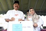 Bupati Kutai Kartanegara Edi Damansyah (kiri) didampingi istri Maslianawati Edi Damansyah (kanan) memasukkan surat suara dalam kotak pada pemungutan suara ulang (PSU) Pilkada Kabupaten Kutai Kartanegara di TPS 22 Arwana di Tenggarong, Kutai Kartanegara, Kalimantan Timur, Sabtu (19/4/2025). PSU pemilihan Bupati dan Wakil Bupati Kutai Kartanegara itu berlangsung di 1.447 tempat pemungutan suara (TPS) dengan daftar pemilih tetap (DPT) sebanyak 552.469 pemilih di 20 kecamatan pascaputusan Mahkamah Konstitusi (MK). Antara Kaltim/M Risyal Hidayat