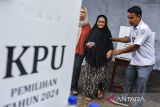 Petugas Kelompok Penyelenggara Pemungutan Suara (KPPS) menggunakan seragam sekolah menuntun warga usai menggunakan haknya pada PSU Pilkada Kabupaten Serang di TPS 05 Nambo Ilir, Kabupaten Serang, Banten, Sabtu (19/4/2025). Penggunaan seragam sekolah oleh petugas KPPS pada pemungutan suara ulang (PSU) Pilkada Kabupaten Serang 2024 tersebut bertujuan untuk menarik perhatian serta meningkatkan partisipasi warga dalam menggunakan hak pilihnya. ANTARA FOTO/Muhammad Bagus Khoirunas/gp