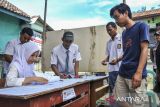 Petugas Kelompok Penyelenggara Pemungutan Suara (KPPS) menggunakan seragam sekolah menuntun warga usai menggunakan haknya pada PSU Pilkada Kabupaten Serang di TPS 05 Nambo Ilir, Kabupaten Serang, Banten, Sabtu (19/4/2025). Penggunaan seragam sekolah oleh petugas KPPS pada pemungutan suara ulang (PSU) Pilkada Kabupaten Serang 2024 tersebut bertujuan untuk menarik perhatian serta meningkatkan partisipasi warga dalam menggunakan hak pilihnya. ANTARA FOTO/Muhammad Bagus Khoirunas/gp
