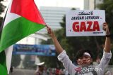 Warga membentangkan poster saat aksi damai bela Palestina di Surabaya, Jawa Timur, Sabtu (19/4/2025). Aksi tersebut sebagai bentuk solidaritas dukungan dan pembelaan terhadap Palestina. ANTARA FOTO/Didik Suhartono/agr