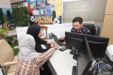 Petugas melayani warga yang mengurus dokumen merek dagang di Kantor Wilayah Kementerian Hukum Jawa Timur, Surabaya, Jawa Timur, Senin (21/4/2025). Kanwil Kemenkum Jawa Timur mencatat sebanyak 10.333 permohonan pelindungan produk kekayaan intelektual pada Triwulan I 2025 dengan penerimaan negara bukan pajak (PNBP) sebesar Rp12,17 miliar. Antara Jatim/Didik Suhartono/mas.