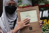 Warga menunjukkan sertifikat merek dagang miliknya di Kantor Wilayah Kementerian Hukum Jawa Timur, Surabaya, Jawa Timur, Senin (21/4/2025). Kanwil Kemenkum Jawa Timur mencatat sebanyak 10.333 permohonan pelindungan produk kekayaan intelektual pada Triwulan I 2025 dengan penerimaan negara bukan pajak (PNBP) sebesar Rp12,17 miliar. Antara Jatim/Didik Suhartono/mas.