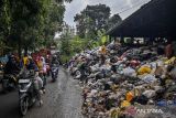 Pengendara melintas di samping tumpukan sampah di TPST Cibeber, Kota Cimahi, Jawa Barat, Senin (21/4/2025). Pemerintah Kota Cimahi memberlakukan status tanggap darurat sampah dengan menghentikan sementara penarikan sampah dari masyarakat ke tempat pembuangan sementara (TPS) selama sepekan, mulai 21-27 April 2025 karena kondisi sampah di TPS telah menumpuk dan akan dilakukan pembersihan. ANTARA FOTO/Abdan Syakura/agr