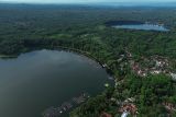 Foto udara Danau Ranu Ranu Pakis dari Danau Ranu Klakah di Desa Tegalrandu, Kecamatan Klakah, Lumajang, Jawa Timur, Senin (21/4/2025). Danau seluas 22 hektare dengan kedalaman mencapai 30 meter yang terbentuk alami dari letusan Gunung Lemongan tersebut menjadi danau terluas di antara tiga ranu di lereng gunung berketinggian 900 mdpl dan menawarkan pemandangan alam berpadu latar gunung juga sejumlah fasilitas wisata perahu motor, becak air, serta kuliner ikan air tawar. ANTARA Jatim/Irfan Sumanjaya/mas.