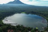 Foto udara wisata Danau Ranu Klakah di Desa Tegalrandu, Kecamatan Klakah, Lumajang, Jawa Timur, Senin (21/4/2025). Danau seluas 22 hektare dengan kedalaman mencapai 30 meter yang terbentuk alami dari letusan Gunung Lemongan tersebut menjadi danau terluas di antara tiga ranu di lereng gunung berketinggian 900 mdpl dan menawarkan pemandangan alam berpadu latar gunung juga sejumlah fasilitas wisata perahu motor, becak air, serta kuliner ikan air tawar. ANTARA Jatim/Irfan Sumanjaya/mas.