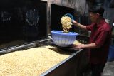 Perajin membuat tempe dari kedelai impor di sentra industri tempe di Sanan, Malang, Jawa Timur, Selasa (22/4/2025). Harga kedelai impor yang terus merangkak naik dari Rp9.100 menjadi Rp9.950 per kilogram sejak dua pekan terakhir sebagai dampak tarif Amerika Serikat membuat perajin tempe setempat memperkecil ukuran tempe dan mengurangi produksi dari lima kwintal menjadi empat kwintal per hari. Antara Jatim/Ari Bowo Sucipto/um