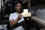 Perajin menunjukkan perbedaan ukuran tempe di sentra industri tempe di Sanan, Malang, Jawa Timur, Selasa (22/4/2025). Harga kedelai impor yang terus merangkak naik dari Rp9.100 menjadi Rp9.950 per kilogram sejak dua pekan terakhir sebagai dampak tarif Amerika Serikat membuat perajin tempe setempat memperkecil ukuran tempe dan mengurangi produksi dari lima kwintal menjadi empat kwintal per hari. Antara Jatim/Ari Bowo Sucipto/um