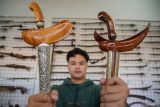 Pekerja memperlihatkan koleksi keris di Galeri Omah Keris, Lumajang, Jawa Timur, Selasa (22/4/2025). Kementerian kebudayaan secara resmi telah menetapkan hari keris nasional pada Jumat (19/4) sebagai upaya memperkenalkan kembali nilai-nilai keris sebagai warisan budaya yang memiliki makna historis, artistik, dan spiritual. ANTARA Jatim/Irfan Sumanjaya/mas.