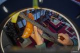 Pekerja memaharkan atau menjual keris melalui siaran langsung media sosial di Galeri Omah Keris, Lumajang, Jawa Timur, Selasa (22/4/2025). Kementerian kebudayaan secara resmi telah menetapkan hari keris nasional pada Jumat (19/4) sebagai upaya memperkenalkan kembali nilai-nilai keris sebagai warisan budaya yang memiliki makna historis, artistik, dan spiritual. ANTARA Jatim/Irfan Sumanjaya/mas.