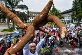 Massa yang tergabung dalam Gerakan Rakyat Selamatkan Bumi menunjukkan hasil bumi saat aksi di Gedung Sate, Jalan Diponegoro, Bandung, Jawa Barat, Selasa (22/4/2025). Aksi yang diselenggarakan dalam rangka Hari Bumi tersebut menuntut Pemerintah Provinsi Jawa Barat untuk mengevaluasi KSO seluruh tambang yang ada di Jawa Barat, realisasi kawasan Puncak Bogor-Cianjur sebagai nuansa etis bagi turis lokal serta berbagai permasalahan lingkungan yang belum terselesaikan di Jawa Barat. ANTARA FOTO/Raisan Al Farisi/agr