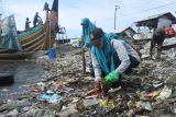 Sejumlah warga memungut sampah di Dermaga Tempat Pelelangan Ikan Desa Kilensari, Panarukan, Situbondo, Jawa Timur, Selasa (22/4/2025). Kegiatan membersihkan pantai yang kotor akibat sampah plastik tersebut dilakukan oleh warga pesisir pantai bersama Dinas Lingkungan Hidup dan Tim Penggerak PKK dalam rangka memperingati Hari Bumi Sedunia. Antara Jatim/Seno/mas.