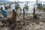 Sejumlah warga memungut sampah di Dermaga Tempat Pelelangan Ikan Desa Kilensari, Panarukan, Situbondo, Jawa Timur, Selasa (22/4/2025). Kegiatan membersihkan pantai yang kotor akibat sampah plastik tersebut dilakukan oleh warga pesisir pantai bersama Dinas Lingkungan Hidup dan Tim Penggerak PKK dalam rangka memperingati Hari Bumi Sedunia. Antara Jatim/Seno/mas.
