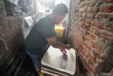 Pekerja memotong tahu di Ketegan Barat, Taman, Sidoarjo, Jawa Timur, Rabu (23/4/2025). Produsen tahu setempat mengeluhkan harga kedelai impor yang sudah naik sejak sepekan terakhir dari Rp7.500 hingga Rp8.000 per kilogram menjadi Rp10.000 per kilogram yang berdampak terhadap meningkatnya biaya produksi tahu dan omzet mereka. Antara Jatim/Umarul Faruq
