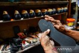 Perajin menyelesaikan produksi sepatu di Sentra Produksi Sepatu Cibaduyut, Bandung, Jawa Barat, Rabu (23/4/2025). Asosiasi Persepatuan Indonesia (Aprisindo) membutuhkan dukungan pemerintah untuk mempermudah ekspor produk alas kaki ke pasar potensial di Uni Eropa untuk mengantisipasi dampak pengenaan tarif resiprokal Amerika Serikat. ANTARA FOTO/Raisan Al Farisi/agr
