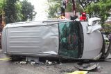 Tim Rescue mengevakuasi mobil yang terbalik di Jalan Kusuma Bangsa, Surabaya, Jawa Timur, Selasa (22/4/2025). Mobil Toyota Avanza bernomor polisi L 1798 PW yang diduga mengalami pecah ban saat melaju itu terbalik usai menabrak mobil Honda Jazz bernomor polisi L 1344 VU yang terparkir dipinggir jalan dan berhenti setelah menabrak mobil Mazda bernomor polisi L 1152 ABZ, serta tidak ada korban jiwa dalam peristiwa tersebut. ANTARA Jatim/Didik Suhartono/mas.