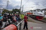 Relawan perlintasan berjaga di perlintasan kereta api sebidang di Ngamprah, Kabupaten Bandung Barat, Jawa Barat, Kamis (24/4/2025). Menteri Perhubungan Dudy Purwagandhi menegaskan bahwa keselamatan masyarakat di 3.693 titik perlintasan sebidang di seluruh Indonesia menjadi perhatian serius menyusul sejumlah kecelakaan yang terjadi di perlintasan tersebut. ANTARA FOTO/Abdan Syakura/agr
