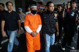 Polisi membawa tersangka korupsi dana desa, ES (tengah) menuju Kejaksaan negeri Tulungagung di Tulungagung, Jawa Timur, Kamis (24/4/2025). Polisi menahan oknum kepala desa nonaktif itu karena diduga melakukan tindak pidana korupsi dana desa tahun anggaran 2020-2021 sehingga menyebabkan kerugian negara sebesar Rp743 juta, sementara satu tersangka lain yang menjabat bendahara desa nonaktif dinyatakan buron. ANTARA Jatim/Destyan Sujarwoko/mas.