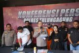 Kapolres Tulungagung AKBP M. Taat Resdi (tengah) menyampaikan pers konferensi terkait penanganan korupsi dana desa dengan tersangka ES (belakang) di mapolres Tulungagung, Tulungagung, Jawa Timur, Kamis (24/4/2025). Polisi menahan oknum kepala desa nonaktif itu karena diduga melakukan tindak pidana korupsi dana desa tahun anggaran 2020-2021 sehingga menyebabkan kerugian negara sebesar Rp743 juta, sementara satu tersangka lain yang menjabat bendahara desa nonaktif dinyatakan buron. ANTARA Jatim/Destyan Sujarwoko/mas.