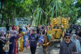Warga menyaksikan arak-arakan tebu manten di Kecamatan Jatiroto, Lumajang, Jawa Timur, Kamis (24/4/2025). Tradisi petik tebu manten yang digelar PT Perkebunan Nusantara (PTPN) 1 Regional 4 Kebun Lumajang Raya bersama PT Sinergi Gula Nusantara Pabrik Gula (PG) Jatiroto tersebut telah menjadi agenda tahunan sebagai bentuk rasa syukur atas melimpahnya hasil panen petani tebu dan menandai awal musim giling. ANTARA Jatim/Irfan Sumanjaya/mas.
