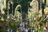 Wisatawan mengunjungi deretan rumah tradisional yang dihiasi oleh Penjor saat Hari Raya Galungan di Desa Wisata Penglipuran, Bangli, Bali, Rabu (23/4/2025). Pengelola desa wisata yang dikunjungi 1.023.143 wisatawan pada tahun 2024 lalu itu berkomitmen untuk terus memperkuat kawasan sebagai destinasi wisata hijau yang mendukung pelestarian lingkungan dan budaya Bali. ANTARA FOTO/Fikri Yusuf/wsj.