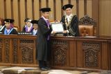 Rektor Universitas Airlangga (Unair) Prof Dr Mochammad Nasih, SE., MT., Ak., CA (kanan) menyerahkan piagam pengukuhan kepada Guru Besar Unair yang baru Prof Dr Hari Basuki Notobroto, dr., M.Kes (kedua kanan) saat sidang terbuka Pengukuhan Guru Besar di Surabaya, Jawa Timur, Kamis (24/4/2025). Unair mengukuhkan enam Guru Besar yang baru di antaranya pasangan suami isteri yaitu Hari Basuki Notobroto dalam bidang Ilmu Biostatistika dan Manajemen Informasi Kesehatan pada Fakultas Kesehatan Masyarakat dan Dwi Winarni dalam bidang Ilmu Histologi Hewan pada Fakultas Sains dan Teknologi. ANTARA Jatim/Moch Asim.