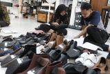Pekerja menata sepatu sebelum dijual secara langsung atau live melalui pasar digital di rumah produksi Shoeka Shoes, Malang, Jawa Timur, Jumat (25/4/2025). Pelaku Usaha Mikro Kecil Menengah (UMKM) sepatu kulit buatan tangan atau handmade setempat berupaya mengatasi persaingan pasar bebas sepatu dengan menggenjot penjualan dalam negeri melalui media sosial maupun pasar digital, membuat inovasi produk baru bertema etnik serta mengikuti pameran di Jepang untuk menjaring konsumen luar negeri. Antara Jatim/Ari Bowo Sucipto/um