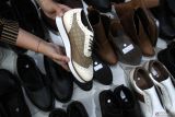 Pekerja menata inovasi baru berupa sepatu bercorak batik etnik sebelum dijual secara langsung atau live melalui pasar digital di rumah produksi Shoeka Shoes, Malang, Jawa Timur, Jumat (25/4/2025). Pelaku Usaha Mikro Kecil Menengah (UMKM) sepatu kulit buatan tangan atau handmade setempat berupaya mengatasi persaingan pasar bebas sepatu dengan menggenjot penjualan dalam negeri melalui media sosial maupun pasar digital, membuat inovasi produk baru bertema etnik serta mengikuti pameran di Jepang untuk menjaring konsumen luar negeri. Antara Jatim/Ari Bowo Sucipto/um