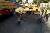 Pekerja melakukan perapian sisa aaspal pada proyek pelebaran dan pengaspalan ulang jalan raya Blitar-Tulungagung di Desa Kunir, Blitar, Jawa Timur, Jumat (25/4/2025). Pelebaran bahu jalan dan pengaspalan ulang dilakukan untuk meningkatkan aksesabilitas antardaerah seiring terus bertambahnya volume kendaraan yang melintas dari Blitar ke Tulungagung maupun sebaliknya. Antara Jatim/Destyan Sujarwoko/um