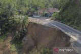 Foto udara jalan longsor di Desa Neglasari, Kabupaten Ciamis, Jawa Barat, Jumat (25/4/2025). Intensitas curah hujan tinggi di wilayah Kabupaten Ciamis mengakibatkan jalan alternatif yang menghubungkan Ciamis dengan Kabupaten Pangandaran dan Kabupaten Tasikmalaya longsor dan hanya bisa dilalui satu jalur atau buka tutup serta tidak bisa dilewati saat hujan deras. ANTARA FOTO/Adeng Bustomi/agr